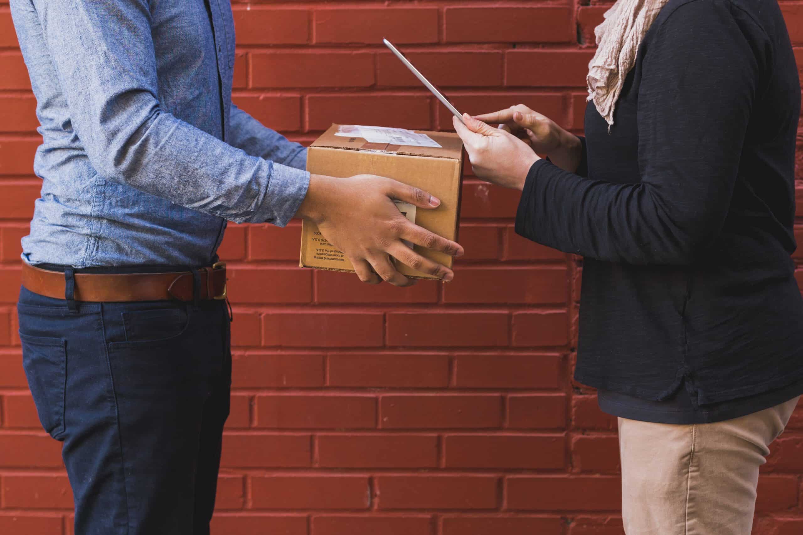 Person delivers box to another person with tablet
