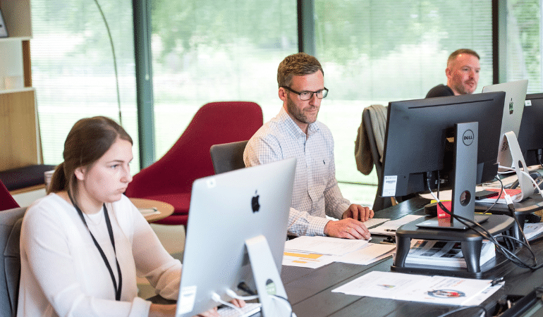 People looking at laptop in a office