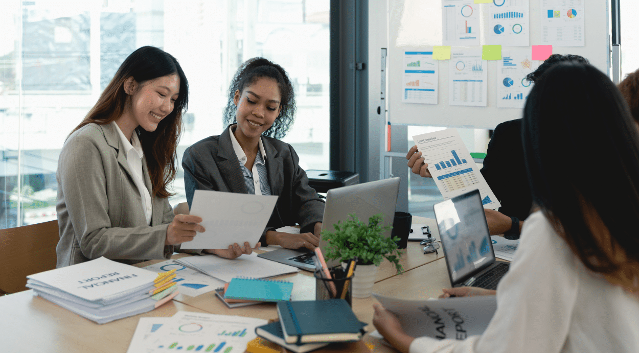 A team of 4 people reviewing financial statements.