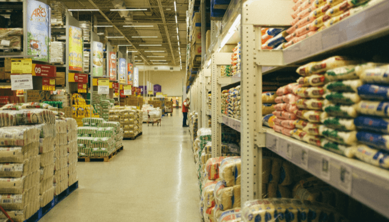 Organized warehouse shelving with stacked food products and pallets, illustrating inventory systems where lot codes ensure traceability.