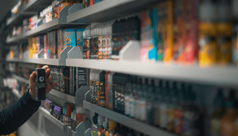 Hand reaching for products on store shelves while checking PAR level inventory and stock management